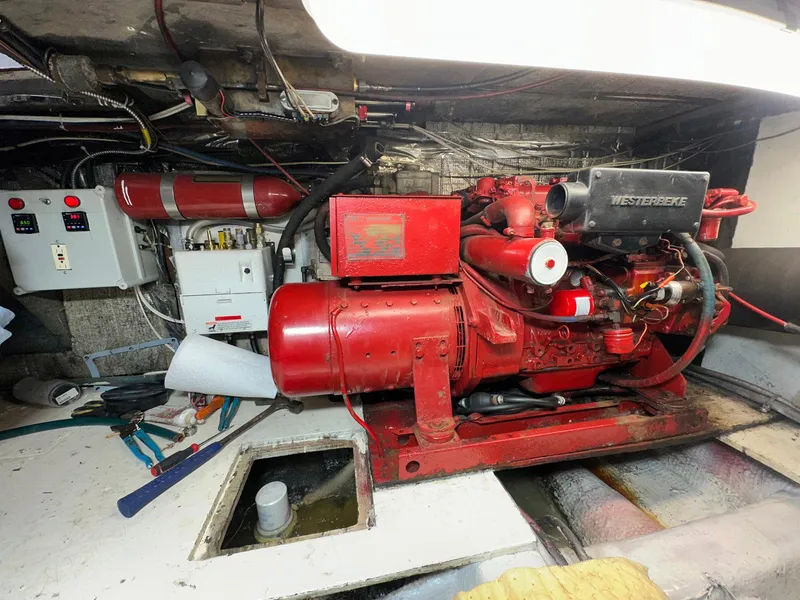 Slide: The Image of Engine room of 1987 Ocean Yachts 48 Super Sport with red machinery and control panels. - 11