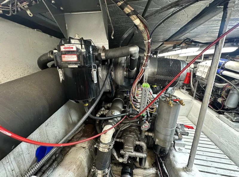 Slide: The Image of Engine room of 1987 Ocean Yachts 48 Super Sport, showcasing mechanical components and wiring. - 14