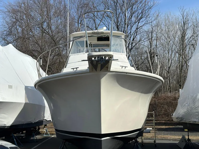 Slide: The Image of 1987 Ocean Yachts 48 Super Sport boat, front view, docked, surrounded by trees. - 19