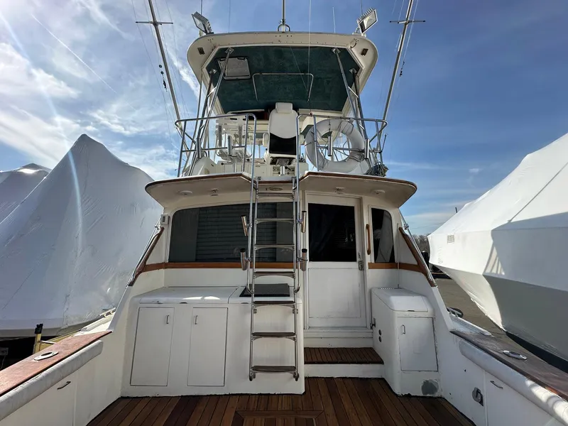 Slide: The Image of 1987 Ocean Yachts 48 Super Sport boat with ladder and deck, under clear sky. - 2