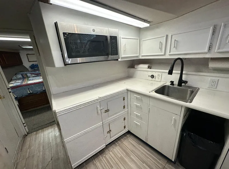 Slide: The Image of 1987 Ocean Yachts 48 Super Sport kitchen with white cabinets and modern appliances. - 6
