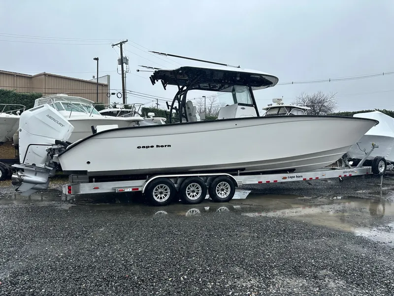Slide: The Image of 2025 Cape Horn 36 XS boat on trailer, parked outdoors on gravel. - 2