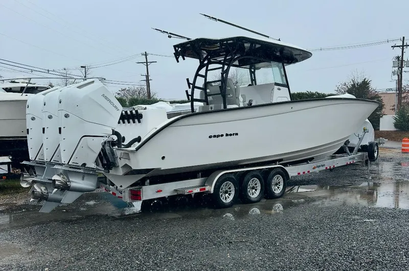 Slide: The Image of 2025 Cape Horn 36 XS boat on trailer, featuring triple engines, parked outdoors. - 3