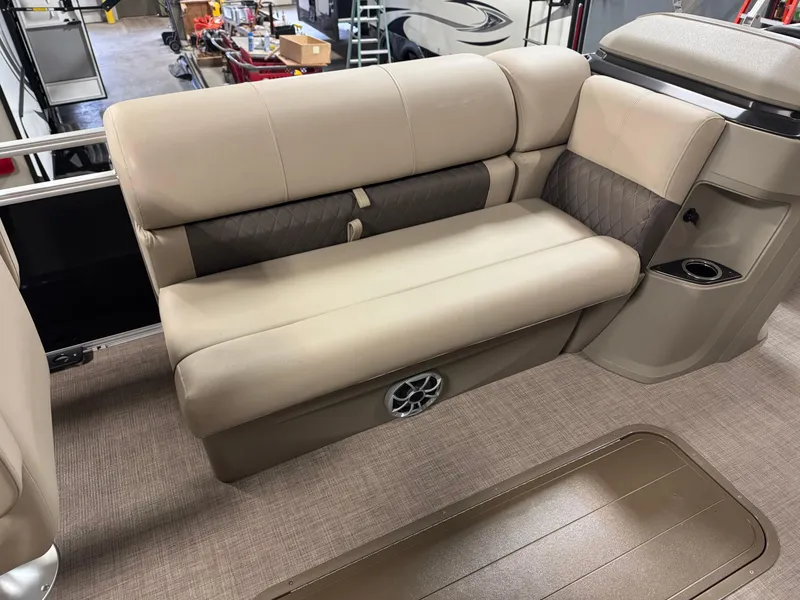 Slide: The Image of 2025 Sun Tracker Sportfish 24 XP3 boat interior with beige seating and speaker. - 13