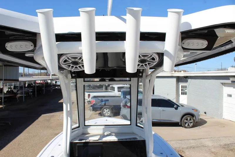 Slide: The Image of 2025 Tidewater 2410 BM boat with rod holders and speakers, parked outdoors. - 13