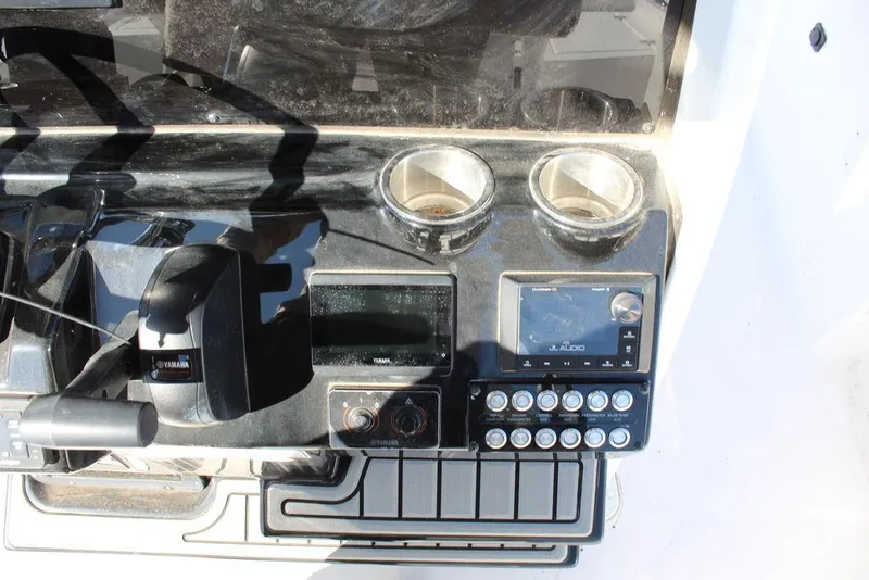 Slide: The Image of Control panel of 2025 Tidewater 2410 BM boat with cup holders and electronic controls. - 14
