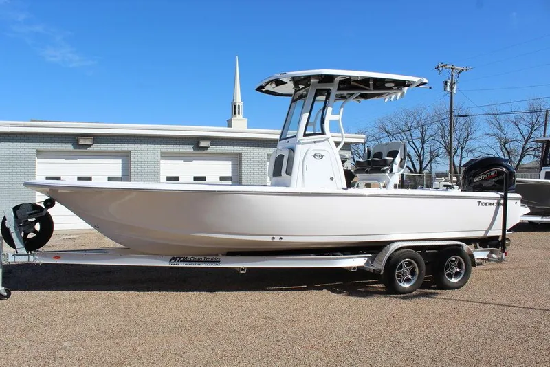 Slide: The Image of 2025 Tidewater 2410 BM boat on trailer, parked outdoors, clear blue sky. - 2