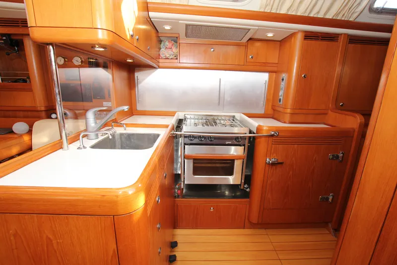 Slide: The Image of Luxurious 2006 Nautor Swan 46mkIII yacht kitchen with wooden cabinetry and modern appliances. - 15