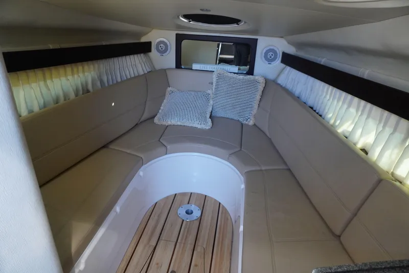 Slide: The Image of 2013 Regal 28 Express cabin interior with beige seating and wooden flooring. - 13