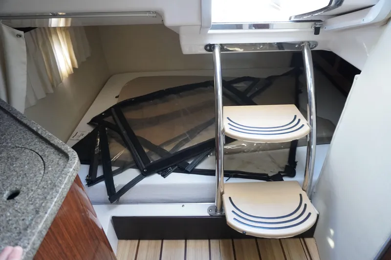 Slide: The Image of Interior of 2013 Regal 28 Express boat with compact cabin and wooden steps. - 15