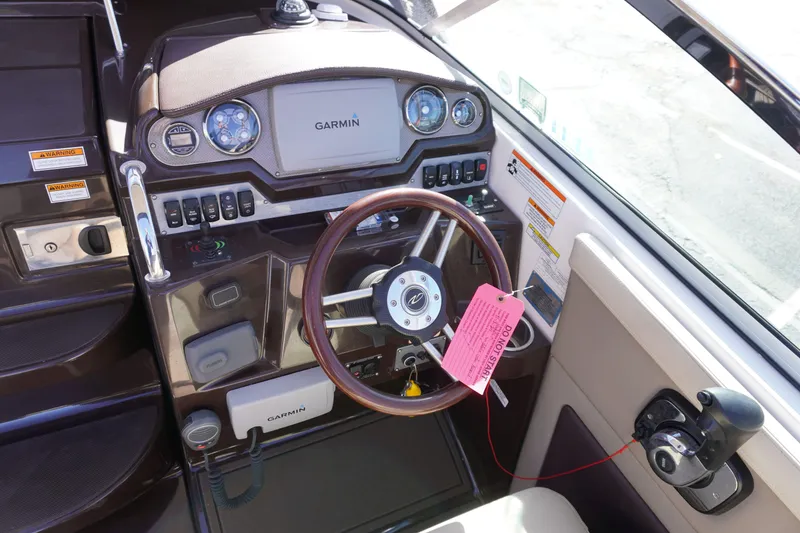 Slide: The Image of 2013 Regal 28 Express boat dashboard with Garmin navigation system and wooden steering wheel. - 7