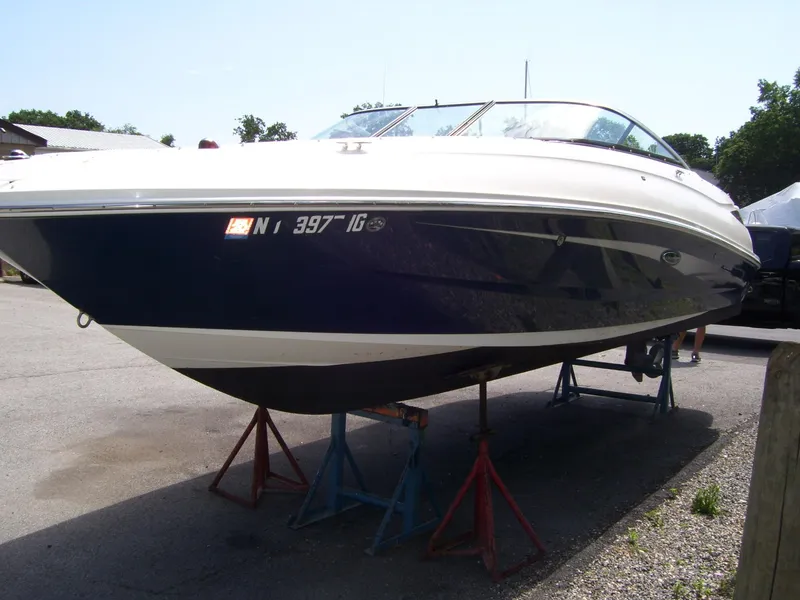 Slide: The Image of 2015 Sea Ray 240 Sundeck boat on stands, parked outdoors. - 2