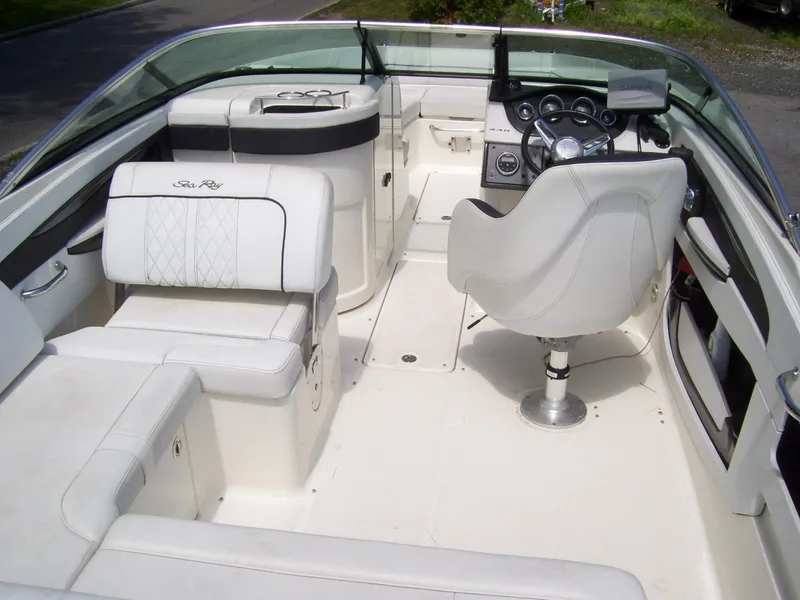 Slide: The Image of 2015 Sea Ray 240 Sundeck interior with white seating and steering console. - 6