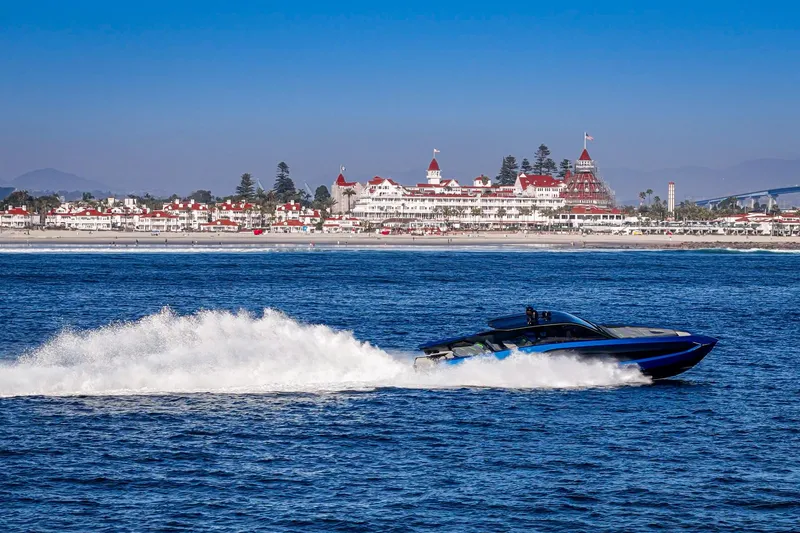 Slide: The Image of 2023 Tecnomar Lamborghini 63 yacht speeding on ocean near historic coastal hotel. - 37