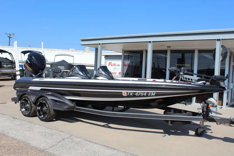 The Image of 2018 Skeeter FX21 LE bass boat on trailer, parked outside a building. - 1