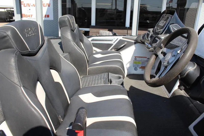 Slide: The Image of 2018 Skeeter FX21 LE boat interior with black and white seating and steering wheel. - 14