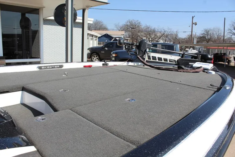 Slide: The Image of 2018 Skeeter FX21 LE boat deck with carpeted surface and trolling motor. - 16