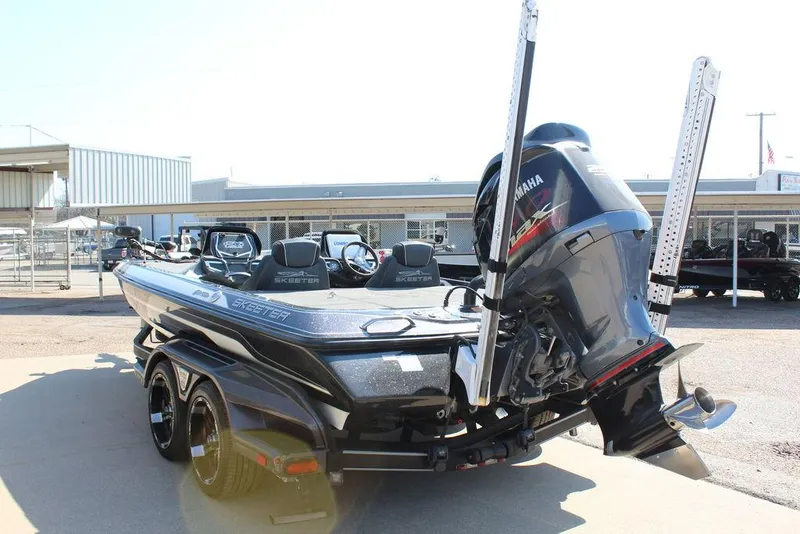 Slide: The Image of 2018 Skeeter FX21 LE bass boat with Yamaha outboard motor, parked on a trailer. - 4