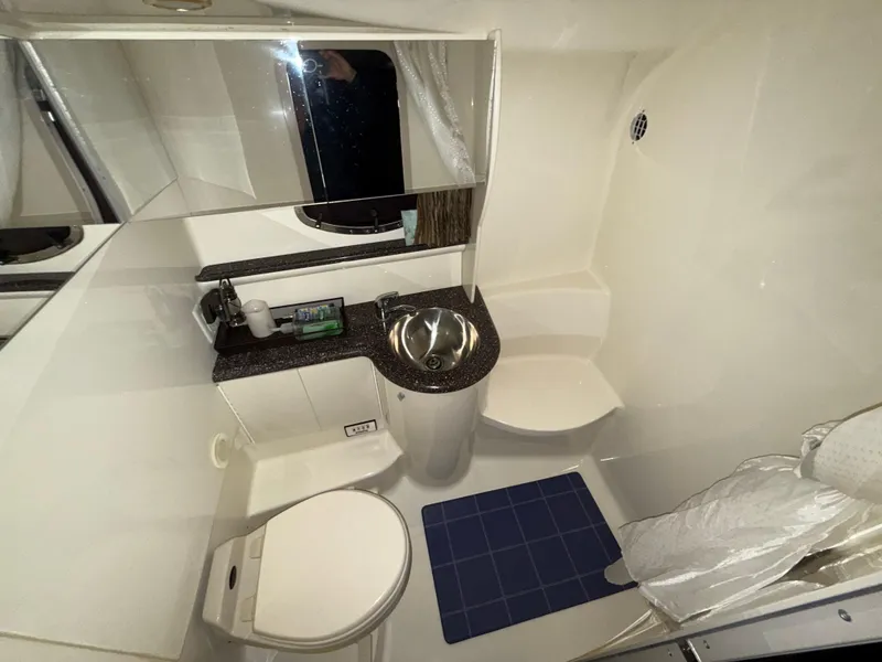 Slide: The Image of Bathroom interior of a 2003 Formula 400ss boat, featuring a sink, toilet, and mirror. - 24