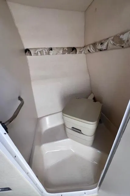 Slide: The Image of 2000 Sea Ray 245 Weekender cabin interior with compact portable toilet. - 11