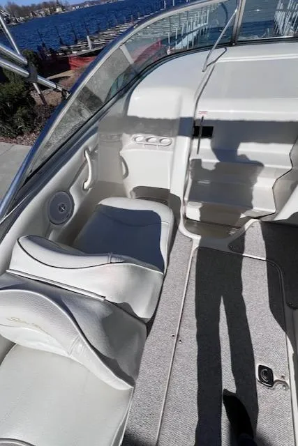 Slide: The Image of 2000 Sea Ray 245 Weekender boat interior with white seating and waterfront view. - 4