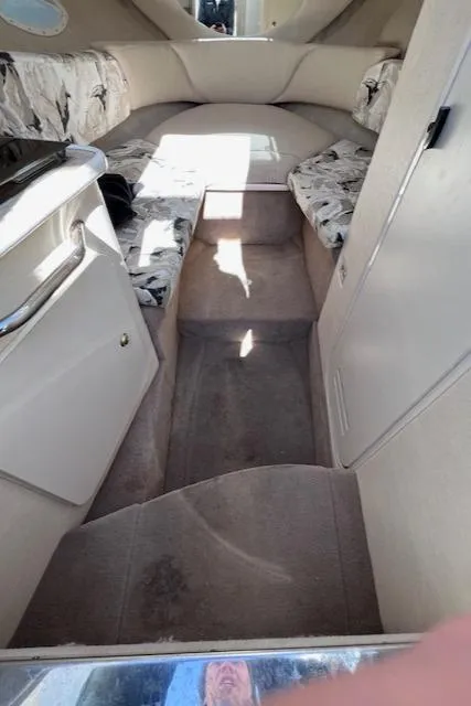 Slide: The Image of Interior of 2000 Sea Ray 245 Weekender boat, featuring cozy seating and compact design. - 8