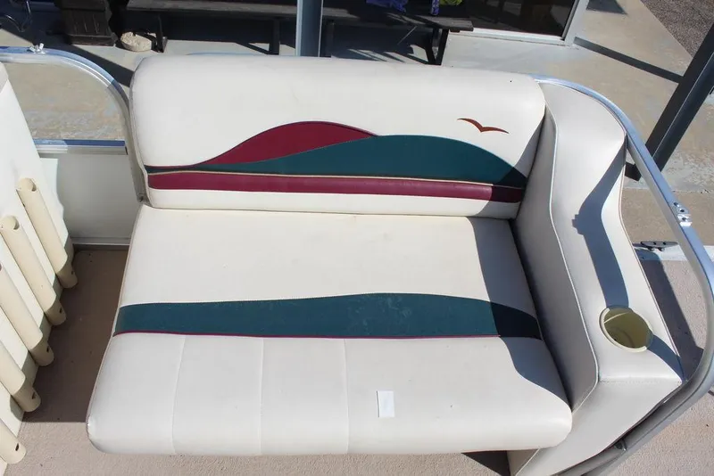 Slide: The Image of 1997 Monark Pontoon boat seat with colorful design and cup holder. - 12