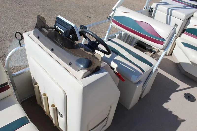 Slide: The Image of 1997 Monark Pontoon boat interior with steering console and seating. - 15