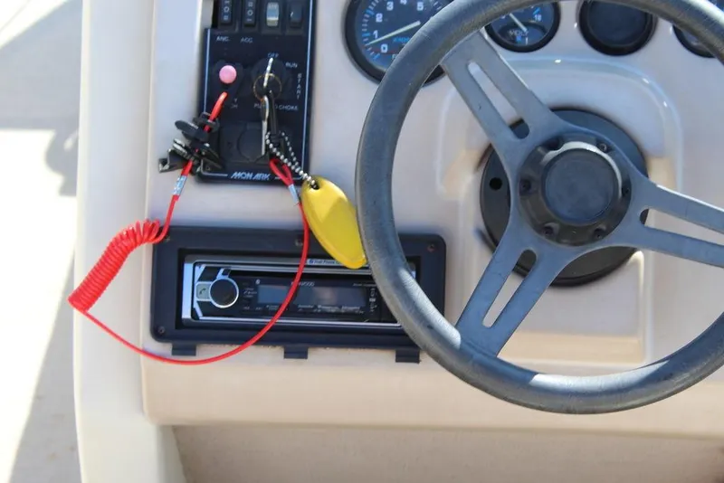 Slide: The Image of 1997 Monark Pontoon boat dashboard with steering wheel and control panel. - 17