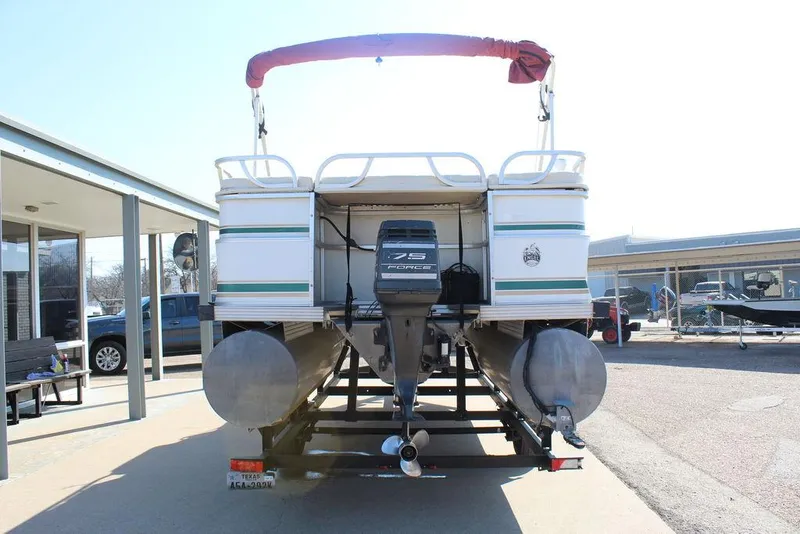 Slide: The Image of 1997 Monark Pontoon boat with 75 horsepower engine, parked on a trailer. - 4