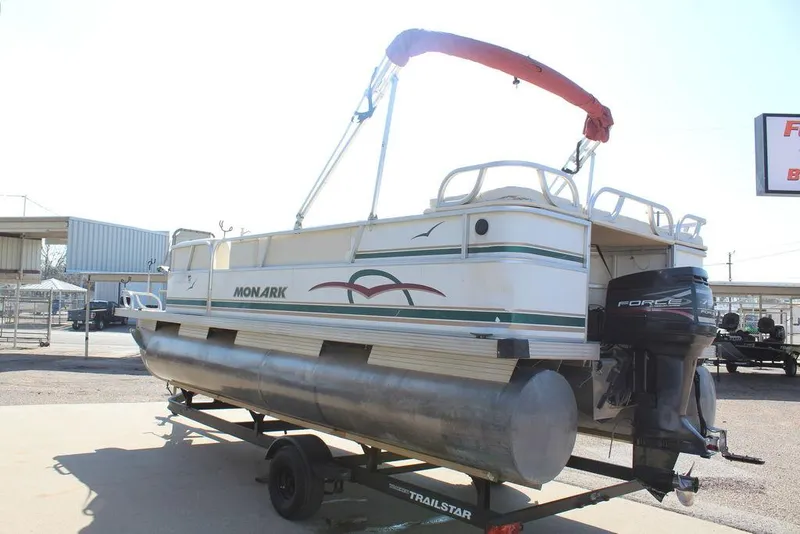 Slide: The Image of 1997 Monark Pontoon boat on trailer with outboard motor, featuring red canopy. - 5