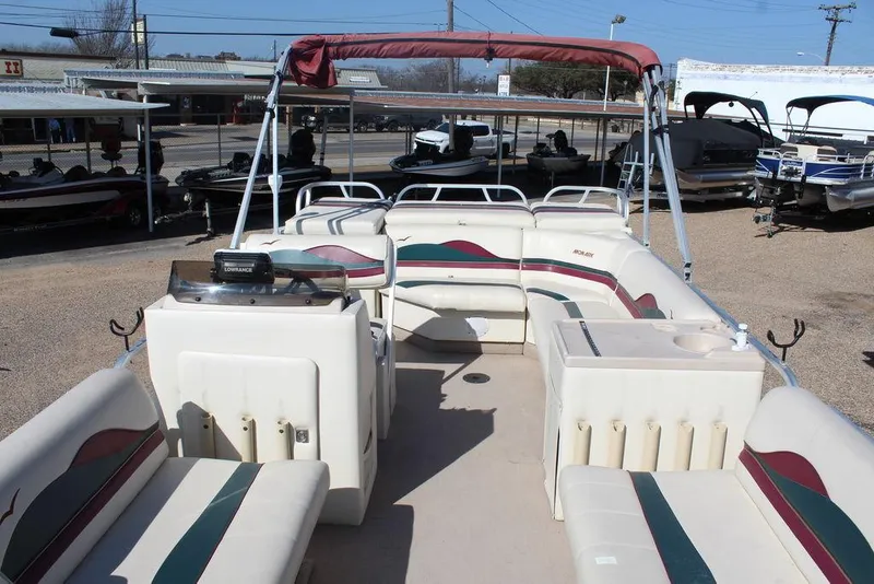 Slide: The Image of 1997 Monark Pontoon boat with spacious seating and canopy, displayed outdoors. - 9