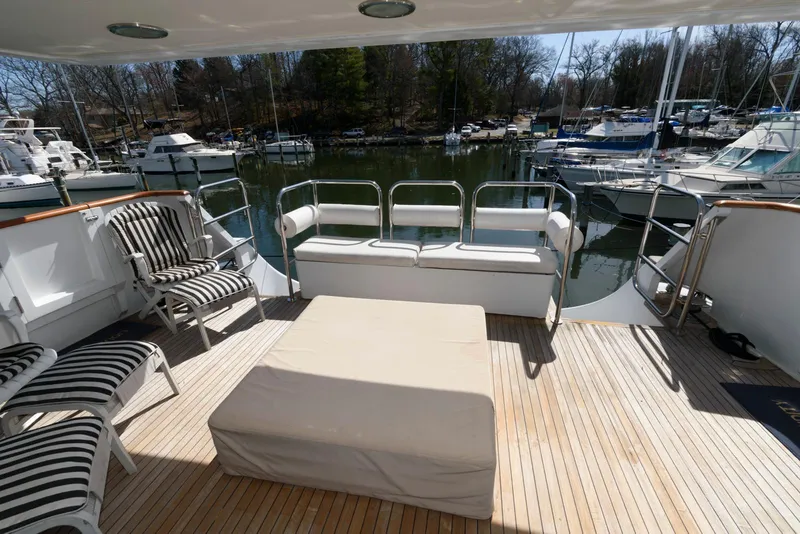 Slide: The Image of Spacious deck of 1984 Broward 100 yacht with seating and scenic marina view. - 10