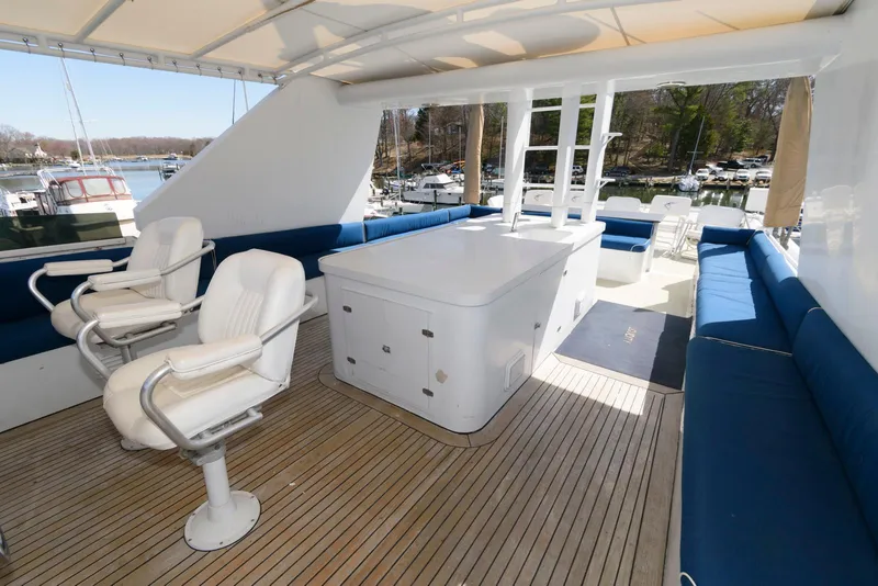 Slide: The Image of Luxurious 1984 Broward 100 yacht deck with seating and helm chairs. - 11