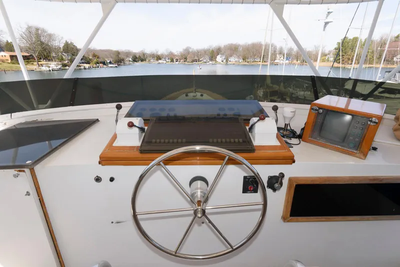 Slide: The Image of Helm of 1984 Broward 100 yacht with steering wheel and navigation equipment. - 14