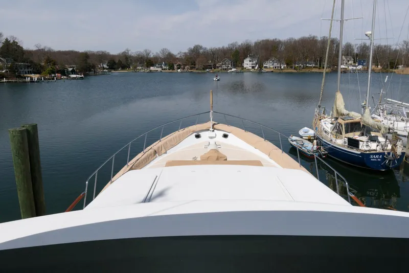 Slide: The Image of Bow view of 1984 Broward 100 yacht docked in a serene marina. - 18
