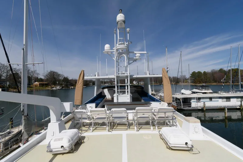 Slide: The Image of Luxury Broward 100 yacht deck, 1984 model, docked at marina under clear blue sky. - 20