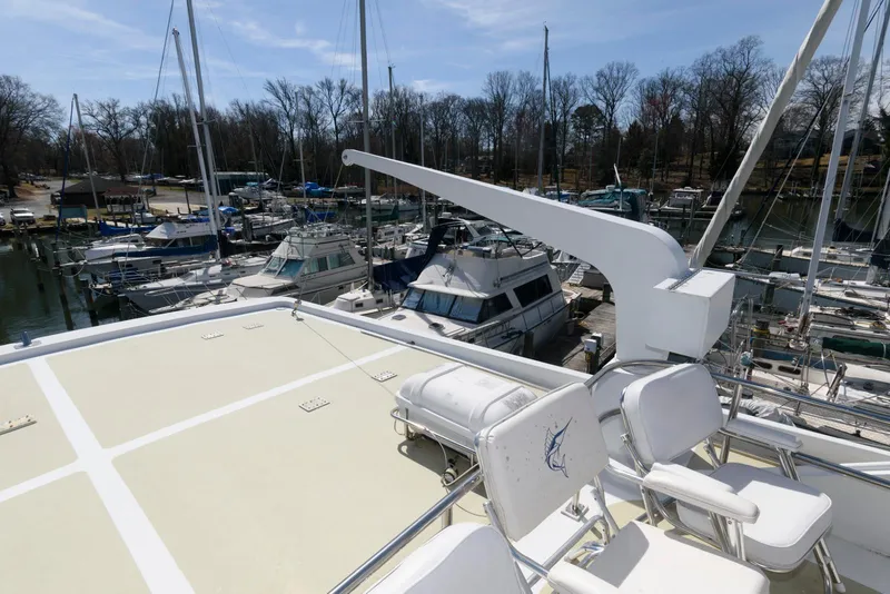 Slide: The Image of Luxury yacht deck view at marina, Broward 100, 1984 model, surrounded by sailboats. - 21