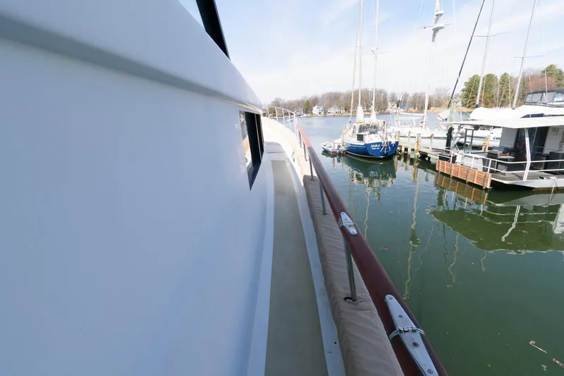 Slide: The Image of Side view of a 1984 Broward 100 yacht docked in a marina. - 23