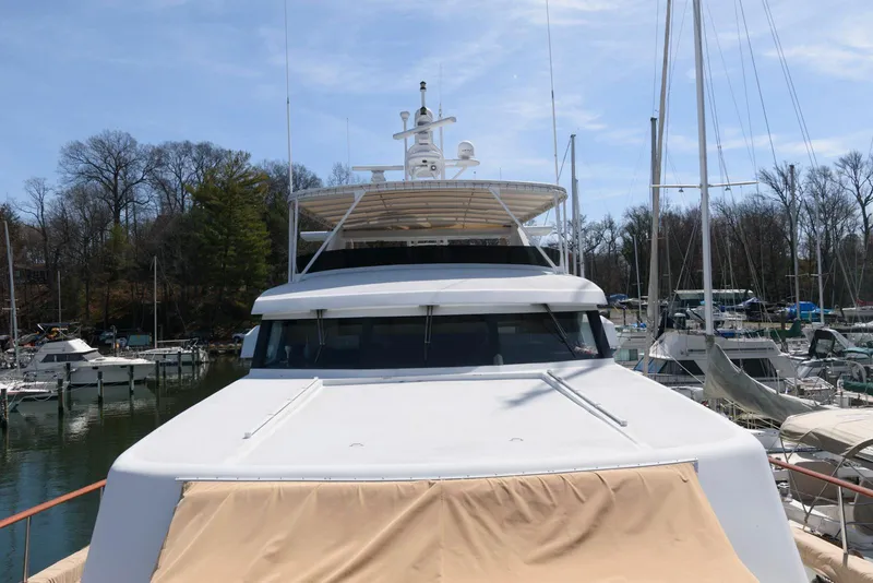 Slide: The Image of Front view of a 1984 Broward 100 yacht docked at a marina. - 26