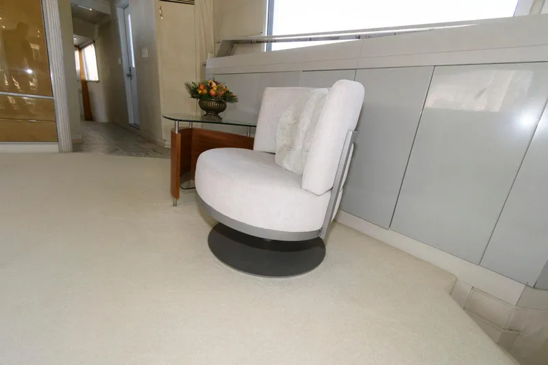 Slide: The Image of Luxurious interior of 1984 Broward 100 yacht with modern white swivel chair. - 33