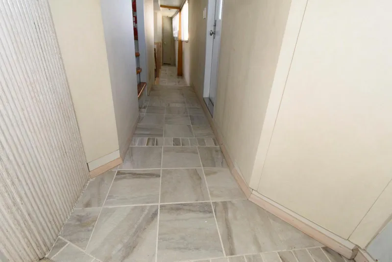Slide: The Image of Narrow hallway with tiled floor on a 1984 Broward 100 yacht. - 35