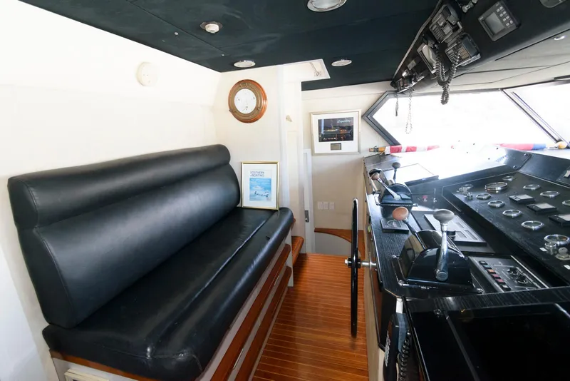 Slide: The Image of Interior of 1984 Broward 100 yacht with black seating and control panel. - 36