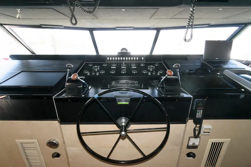 Slide: The Image of Cockpit of 1984 Broward 100 yacht with steering wheel and control panels. - 37