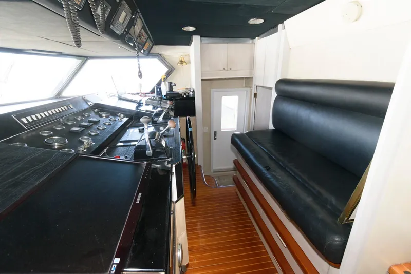 Slide: The Image of Cockpit of 1984 Broward 100 yacht with control panel and black seating. - 38