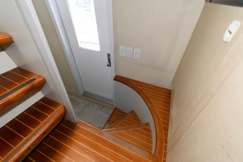 Slide: The Image of Wooden staircase and door inside 1984 Broward 100 yacht, featuring elegant design. - 39