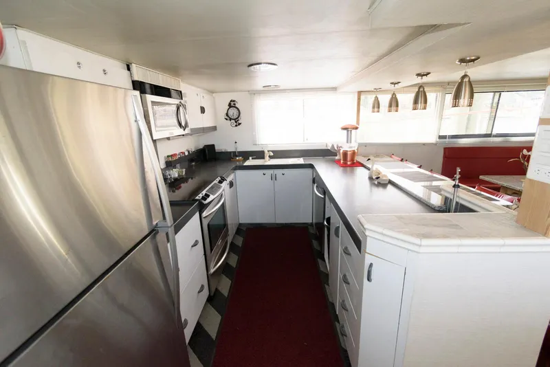 Slide: The Image of Modern kitchen interior on a 1984 Broward 100 yacht, featuring stainless steel appliances and sleek design. - 41