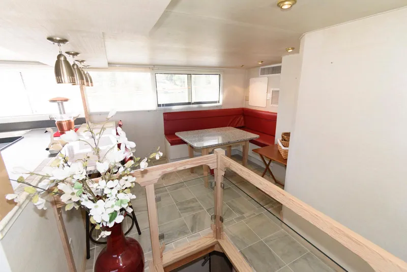 Slide: The Image of Interior of 1984 Broward 100 yacht with red seating and floral decor. - 43