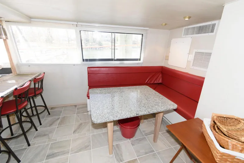 Slide: The Image of Red seating area with granite table on 1984 Broward 100 yacht interior. - 44