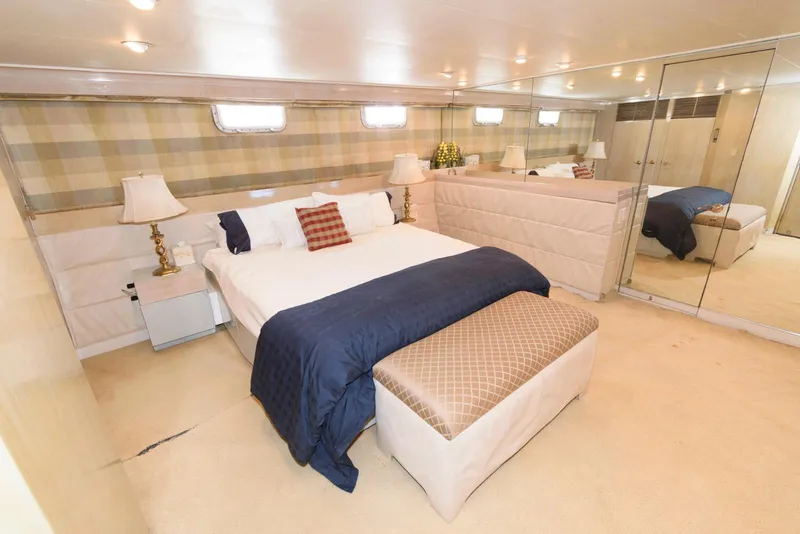 Slide: The Image of Luxurious bedroom in 1984 Broward 100 yacht with elegant decor and mirrored walls. - 46